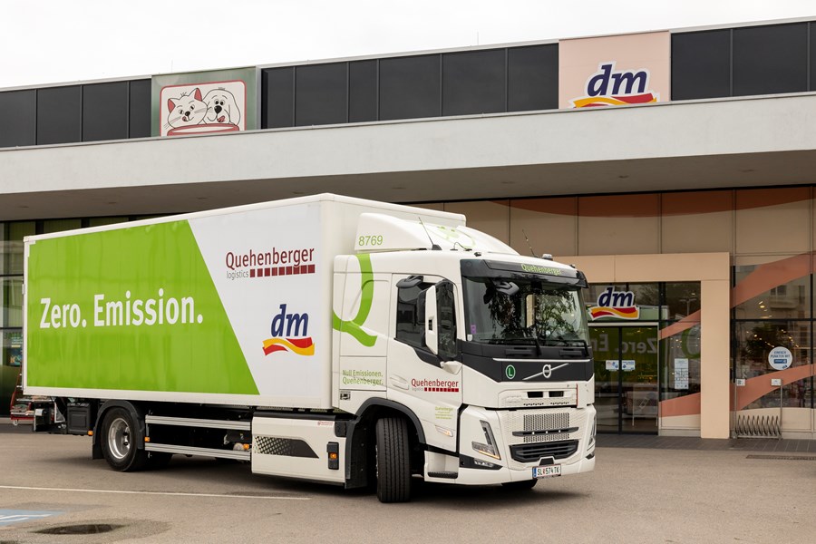 Ein E-LKW steht vor einem dm Markt.